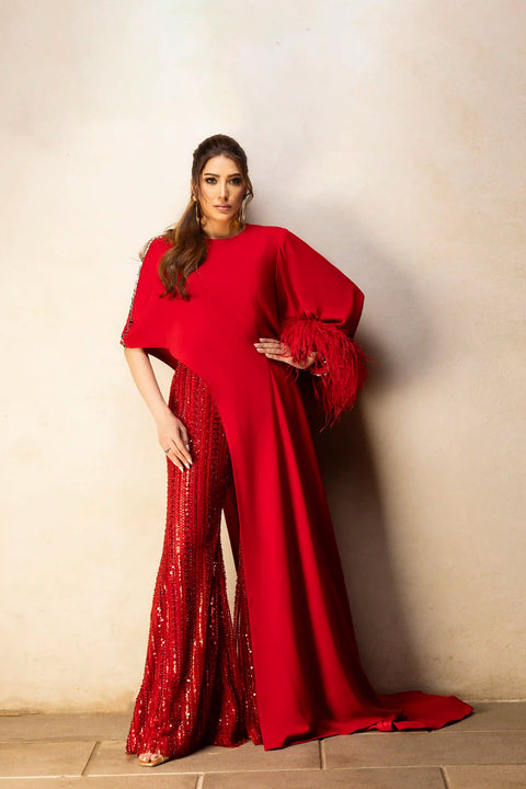 Red asymmetrical top with beaded pants