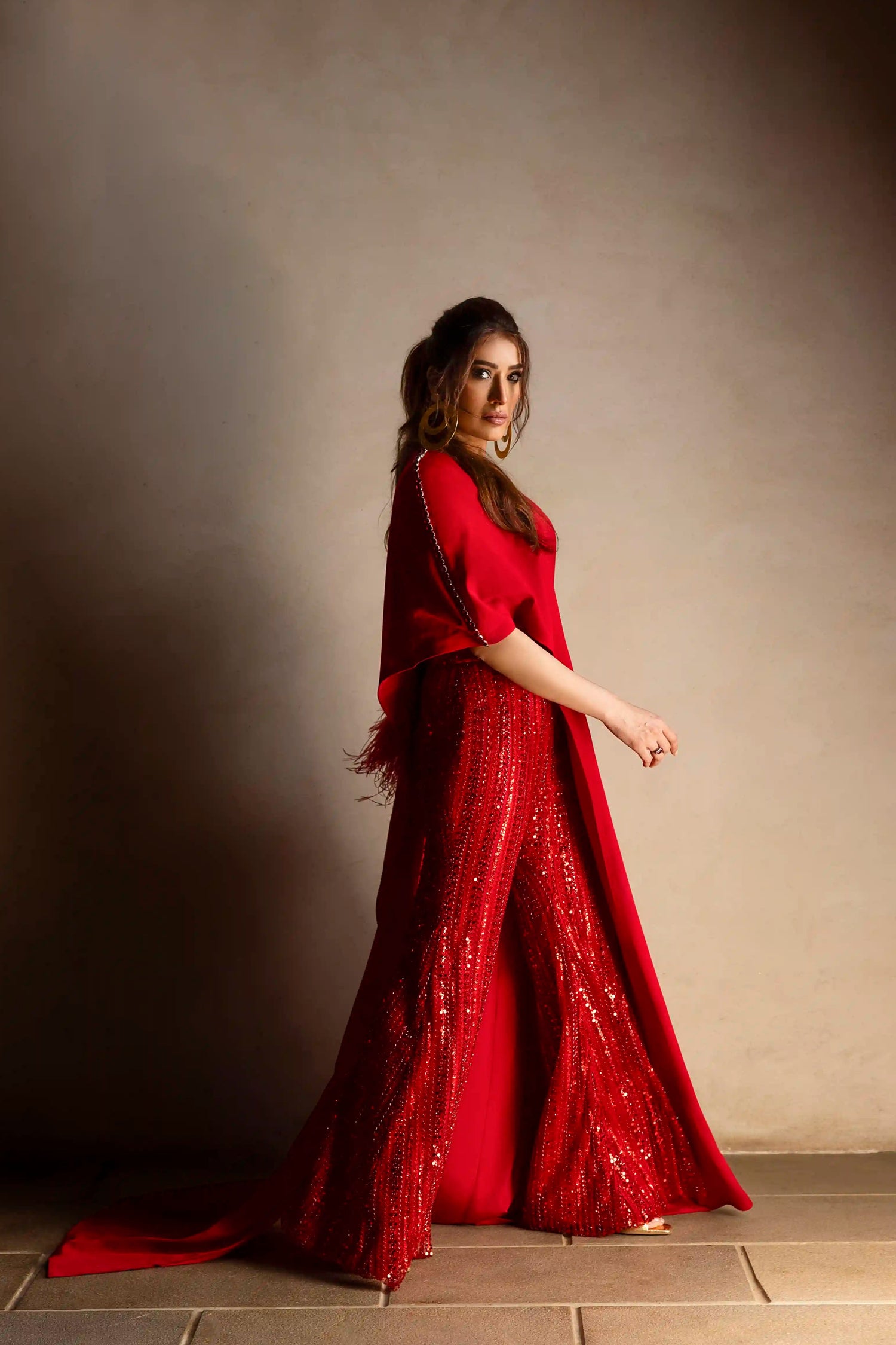 Red asymmetrical top with beaded pants