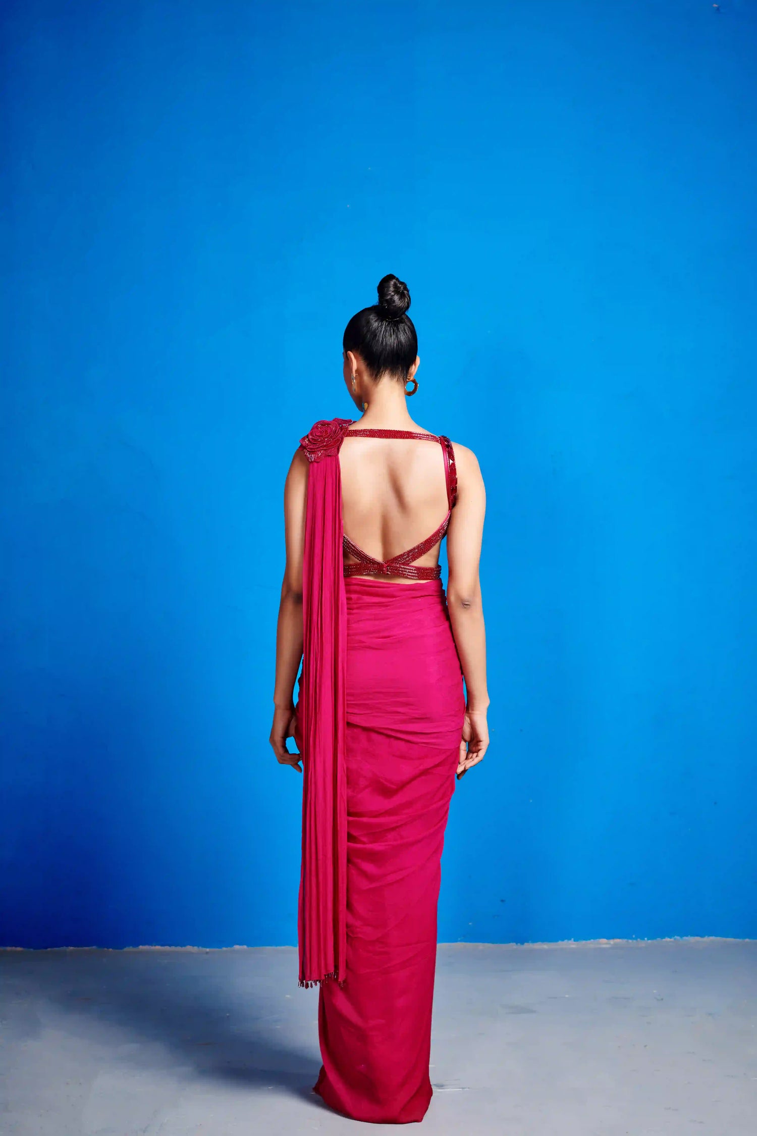 Woman in a pink saree with a blue background